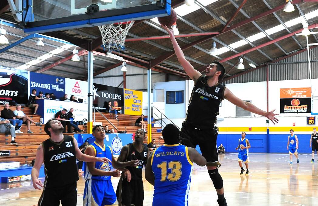 SLAM DUNK: Sydney City Cobras' Sam McCorkindale soars to score with a finger-roll against the Parramatta Wildcats. Photo: NOEL ROWSELL 102416bball