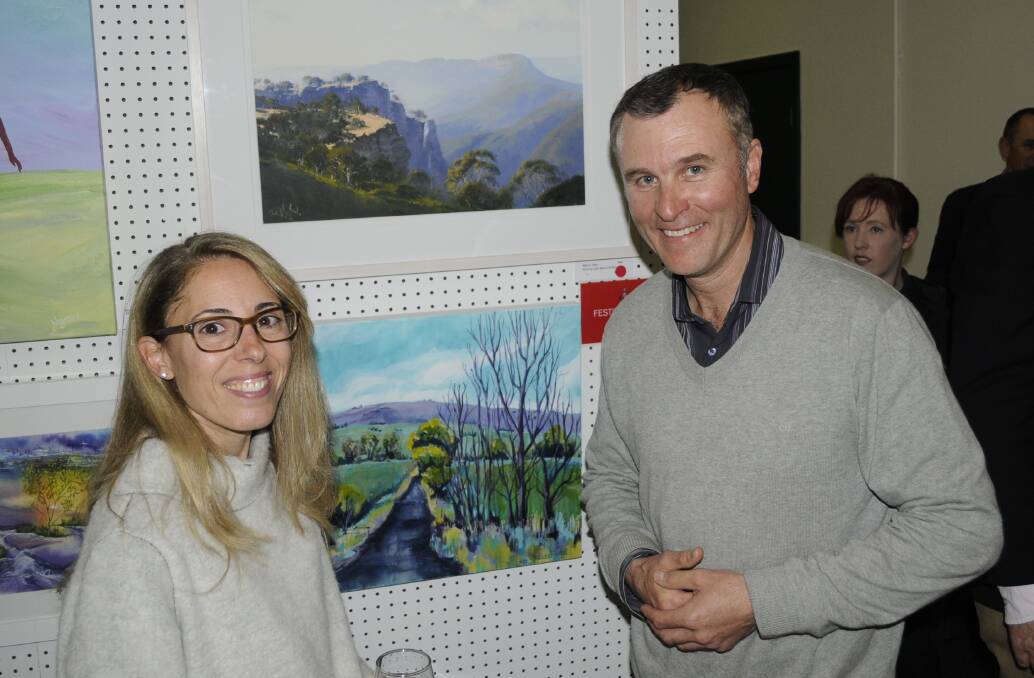 BUYERS: The winning art purchasers, Yanina and Stephen Lenehan, with the painting above them. 091016cart3