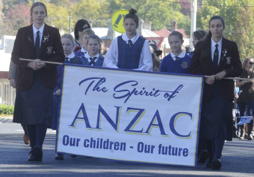 COMMEMORATING: Bathurst school students carry the Spirit of the Anzac sign during last year's Anzac Day Parade. Photo: CHRIS SEABROOK