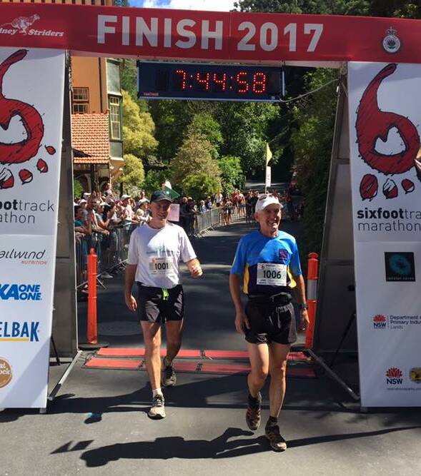 FINISHED: Ba-Thirst Runners' Stephen Jackson (right) crossing the finish line at the Six Foot Track Marathon in 2017. Photo: SIX FOOT TRACK MARATHON RACE FACEBOOK PAGE