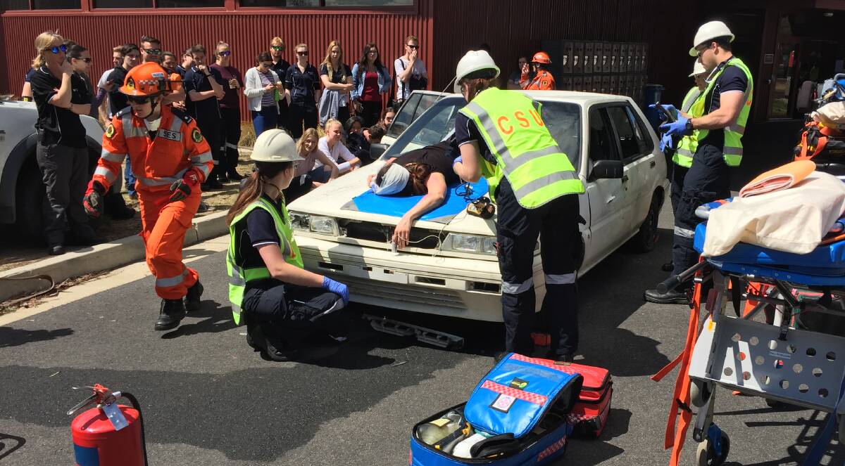 SIMULATION: Paramedic students were at work in a practical exercise on Friday to safely remove a group of students from a car. Photo: BRADLEY JURD 092917csu1