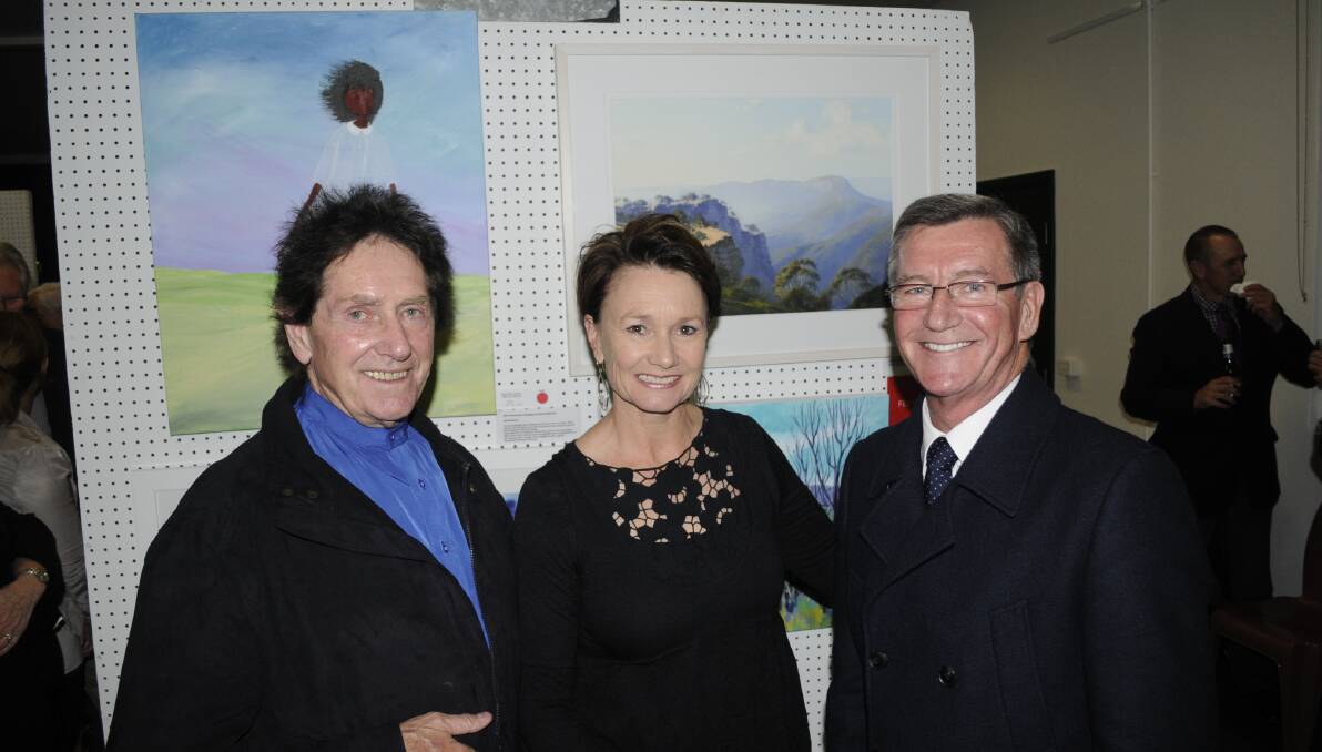 CHAMPION: Winning artist John Wilson with Trudy O'Connor, mayor Gary Rush and Mr Wilson's painting titled Morning Light Mount Solitary. 091016cart2
