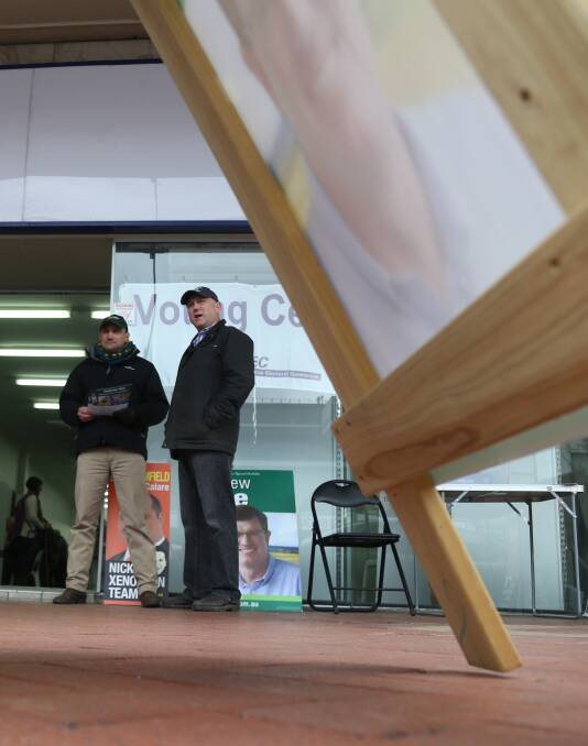 Prepoll volunteers Scott Barrett and Scott Munro hand out how-to-vote cards at Orange. Photo: PHIL BLATCH