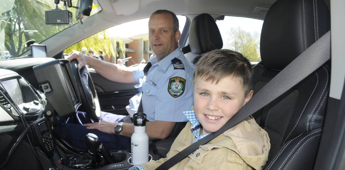 SNAPSHOT: Sergeant Peter Foran, of Bathurst Highway Patrol, with Macalister Heath-Pearce, 9, from Crudine. Photo: CHRIS SEABROOK 100516cparad1