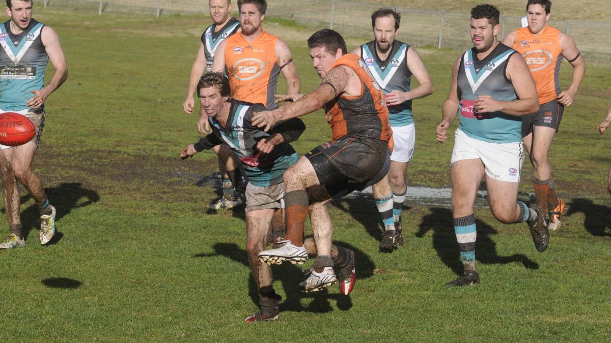 ORDINARY DAY: Giants player Adam Dredge-Chritchley (right) manages to clear the ball from Bushrangers Outlaws player John Ellis during the Outlaws’ big win on Saturday. Photo: CHRIS SEABROOK	 062516cafl6e