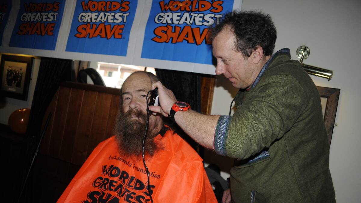 HARD AT WORK: Warren Gunning has his beard shaved off by Glen Lewin. 090416cshave9