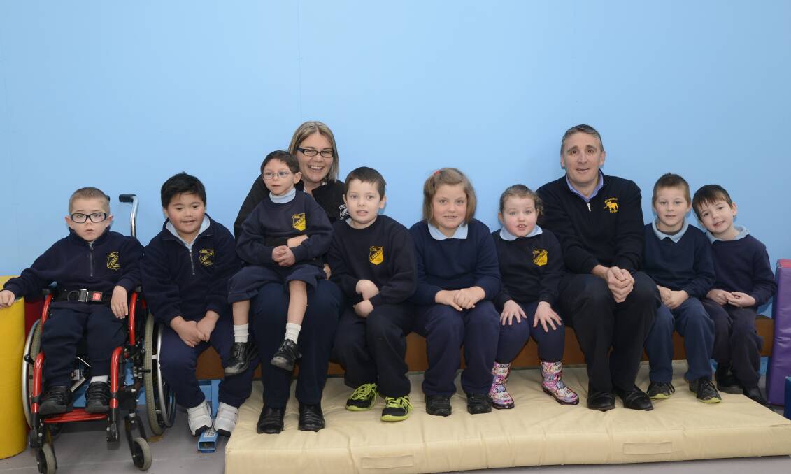 TOP CLUB: Carenne School students Darius, Jericho, Alex, Riley, Ella, Adison, Seth and Anthony, with relieving principal Jane Crosland and Bathurst Bulldogs Rugby Club treasurer Matt Sharwood, who presented the school with a significant donation. Photo: PHILL MURRAY	 061616pbulldogs
