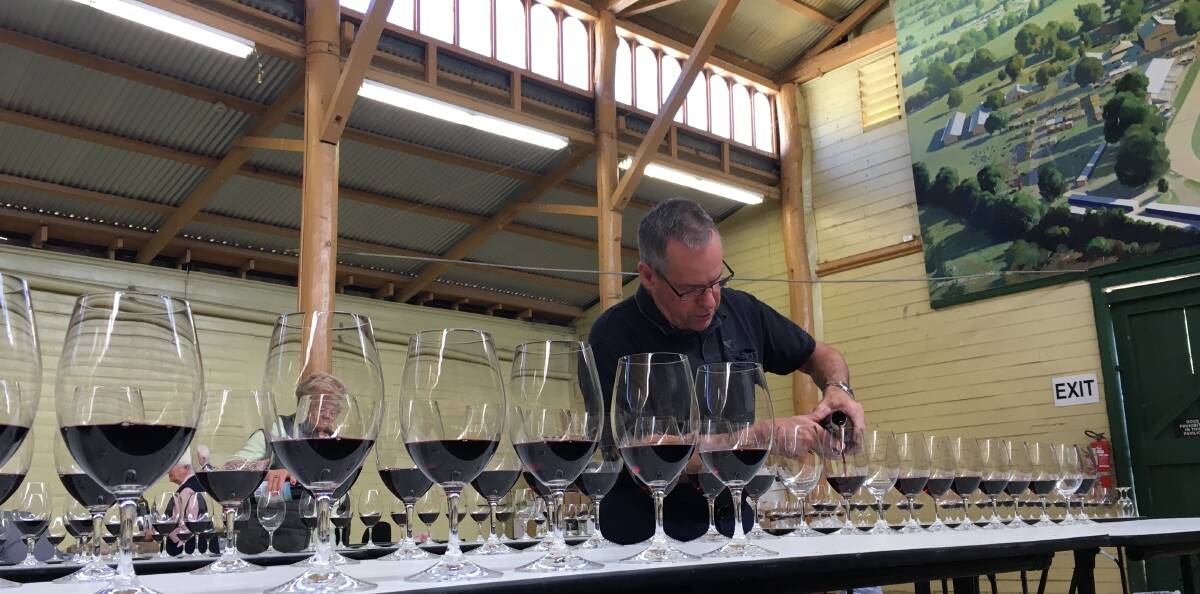 SNAPSHOT: Wine show volunteer Tony Thurling filling wine glasses for judges at Bathurst Showground on Thursday. Photo: NADINE MORTON 102716nmwine