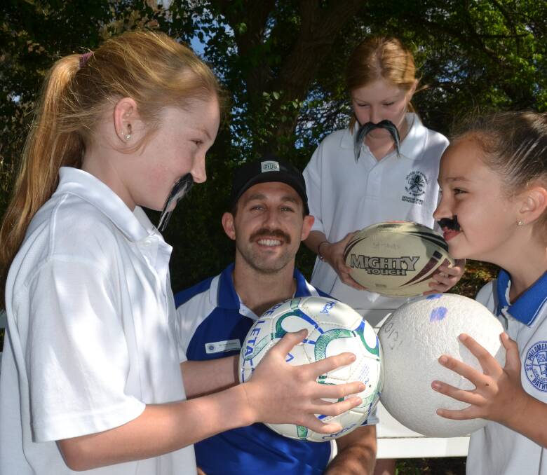 MO KNOWS: Hannah Dunn, Ruby Dunn and Polly Taylor try some intimidation on teacher Jacob Parslow before the Movember Games.