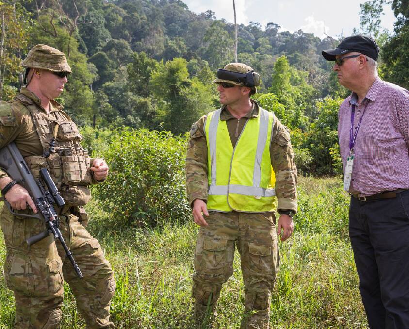JUNGLE LOOK: Private Greg Davies, of Rifle Company Butterworth rotation 116, receives a debrief from Corporal Andy Yates in Malaysia, watched by NSW Commissioner of Corrective Services Peter Severin. Photo: SUPPLIED