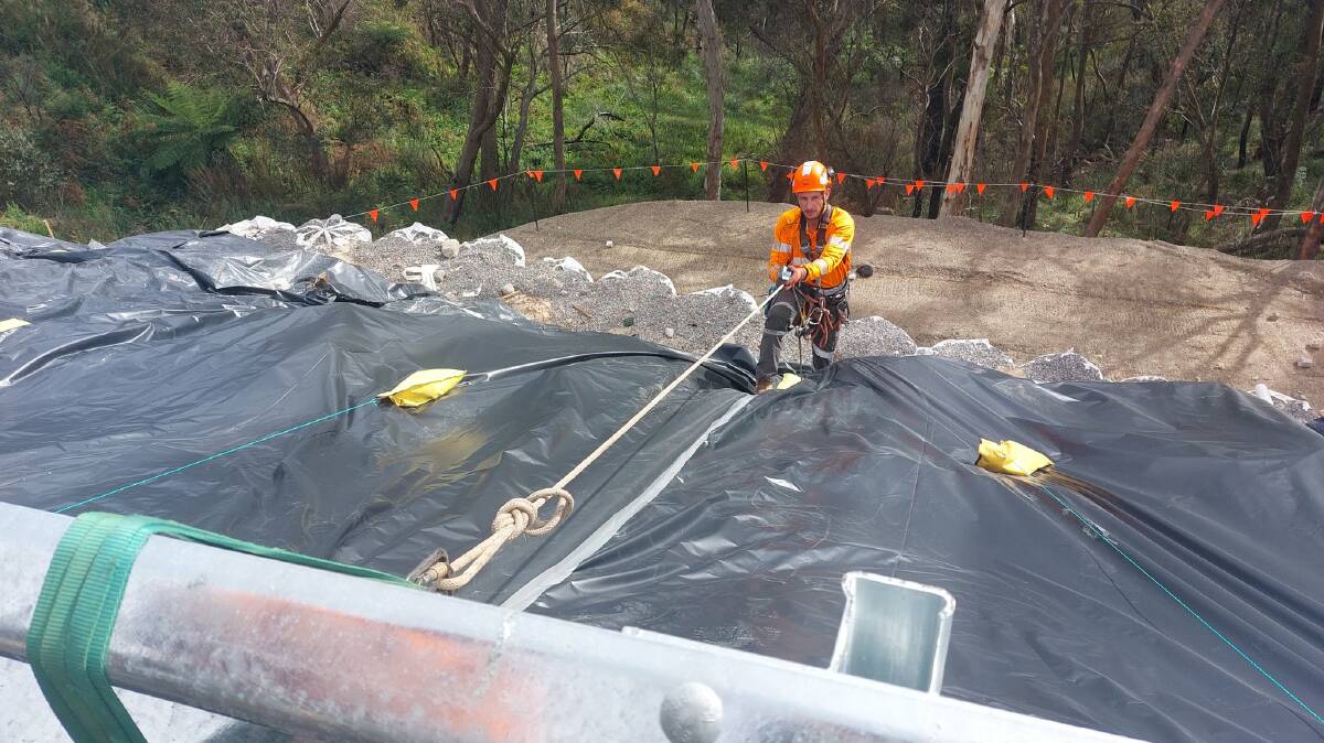 A crew member working to get both lanes of the Great Western Highway open again at Mount Victoria in March 2022 after heavy rain. Picture from Transport for NSW