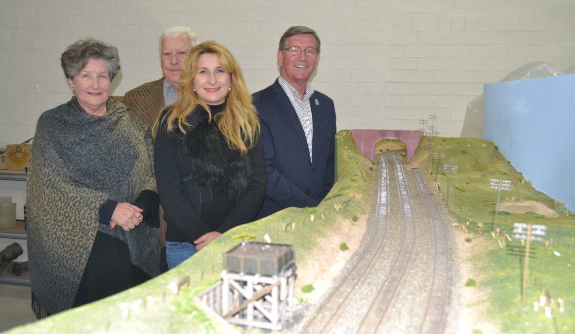 MUSEUM CENTREPIECE: Bonny and Paul Hennessy, their daughter Siobhan Hennessy and Bathurst mayor Gary Rush with the huge model railway that will be showcased in a planned train museum for the city. Photo: NADINE MORTON 	042015nmtrain2