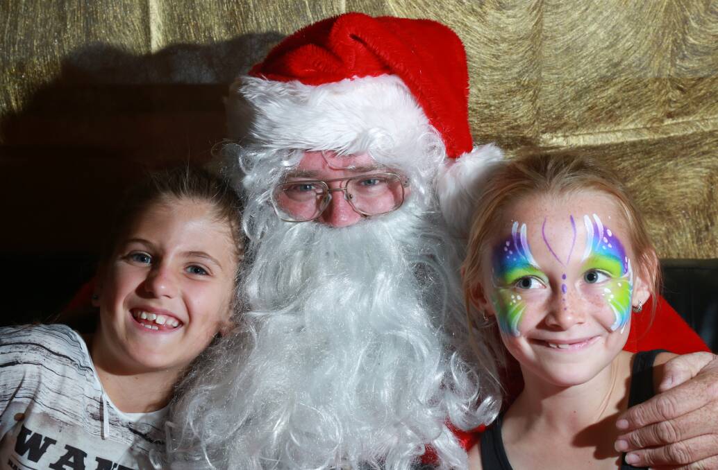 THE JOLLY MAN: Emily Kelly and Montanna Bailey with Santa at the Kelso Public School Fete. Photos: PHIL BLATCH 1203016pbkelso1