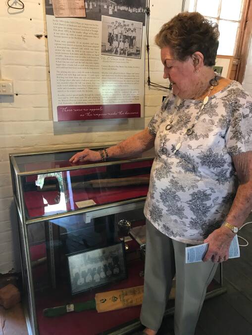 HIT: Joyce Cranston looks at the original cricket bat and ball used by the Rockley Game girls' team.