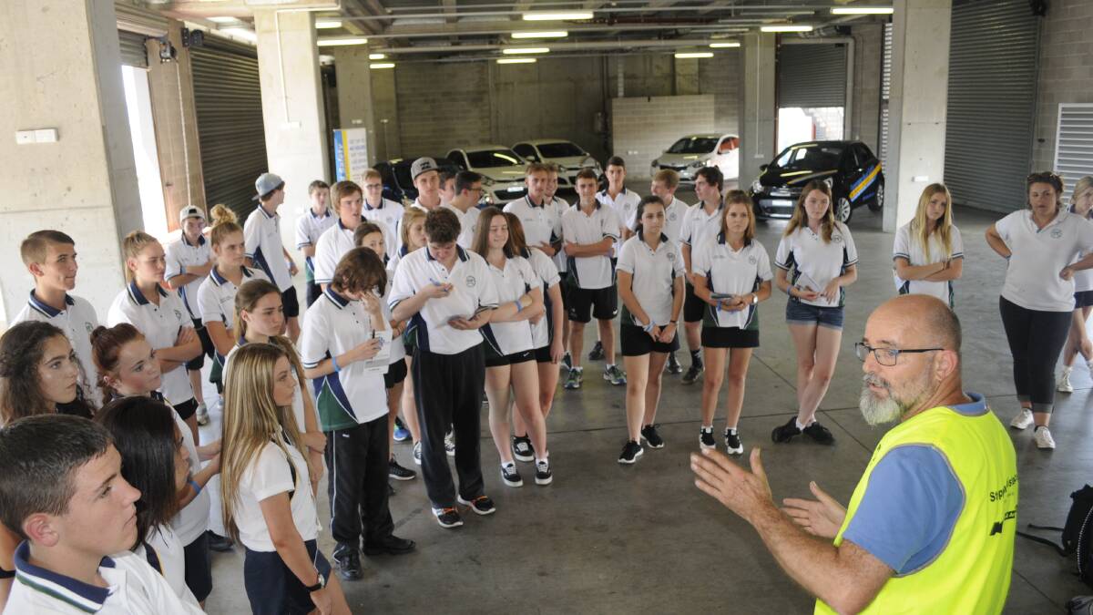 LIFE LESSONS: Panorama Road Safety instructor Robert Dudley addresses Year 11 students from Bathurst and Kelso high schools during this year’s Rotary Youth Driver Awareness program in the Mount Panorama pits. Photo: CHRIS SEABROOK	 022216cdrivred1