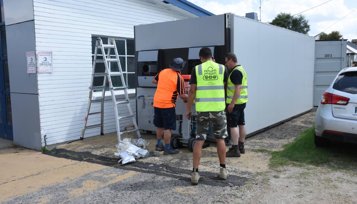 IN PLACE: The Return and Earn reverse vending machine being installed in South Bathurst in December. Photo: NADINE MORTON 122217nmreturn1