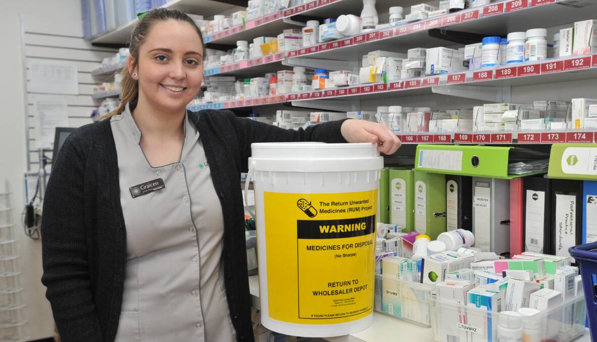 DO THE RIGHT THING: Graicen Fitzalan, a junior pharmacy assistant, with a Return Unwanted Medicines disposal bin. Photo: JUDE KEOGH 0704jkmedicine1