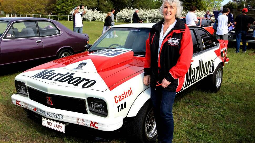Bev Brock, former partner of King of the Mountain Peter Brock, has called for the public’s help to find a stolen piece of the legend’s racing memorabilia. Mrs Brock is pictured with Brocky’s Holden Torana at Morpeth during last month’s Torana Festival in Maitland. Photo: PHIL HEARNE