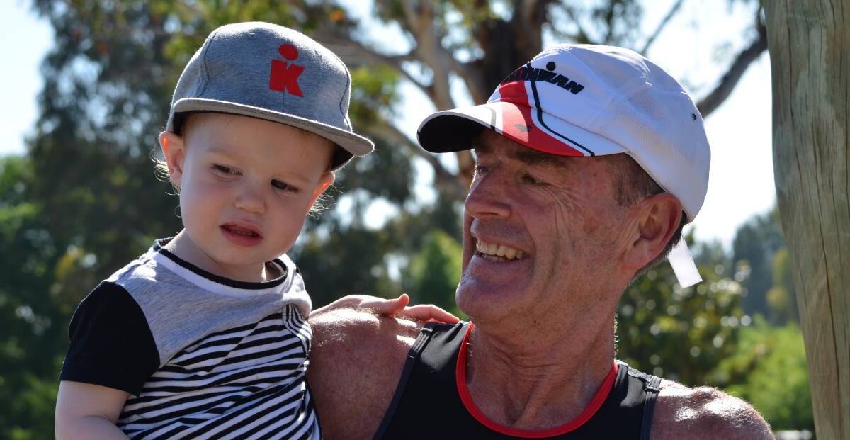GET IN YOUNG: Long course winner Mark Windsor with his grandson Leo, both wearing Ironman hats. Photo: ANYA WHITELAW