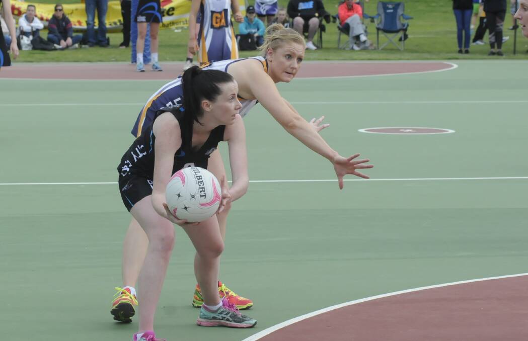 LOOKING FOR OPTIONS: City Colts centre Tegan Kastelein tries to feed the ball into the circle under pressure from Brooke Burgess. Photo:CHRIS SEABROOK 091716cnetgf1