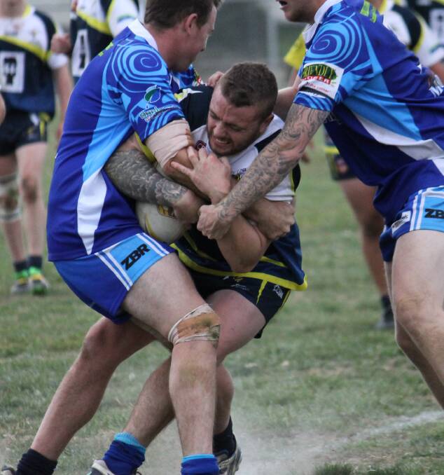DETERMINATION: CSU coach Riley Scelly tries to bust this two-man Wallerawang tackle when the two sides met earlier this season. On Saturday the Mungoes face the Warriors in the grand final. Photo: JOHN FITZGERALD