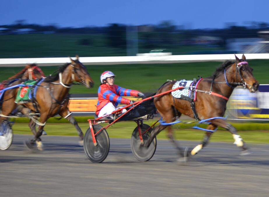 COMING HOME: Written In Style, with Amanda Turnbull in the gig, takes the lead down the home straight at the Bathurst Paceway on Friday night. Photo: ANYA WHITELAW 093016ypace