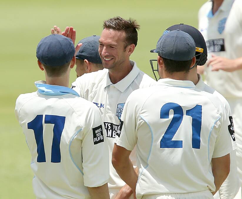NICE WORK: Trent Copeland is offered congratulations from his New South Wales team-mates after taking a wicket in the Sheffield Shield match against Queensland. The Blues won by six wickets. Photo: AAP
