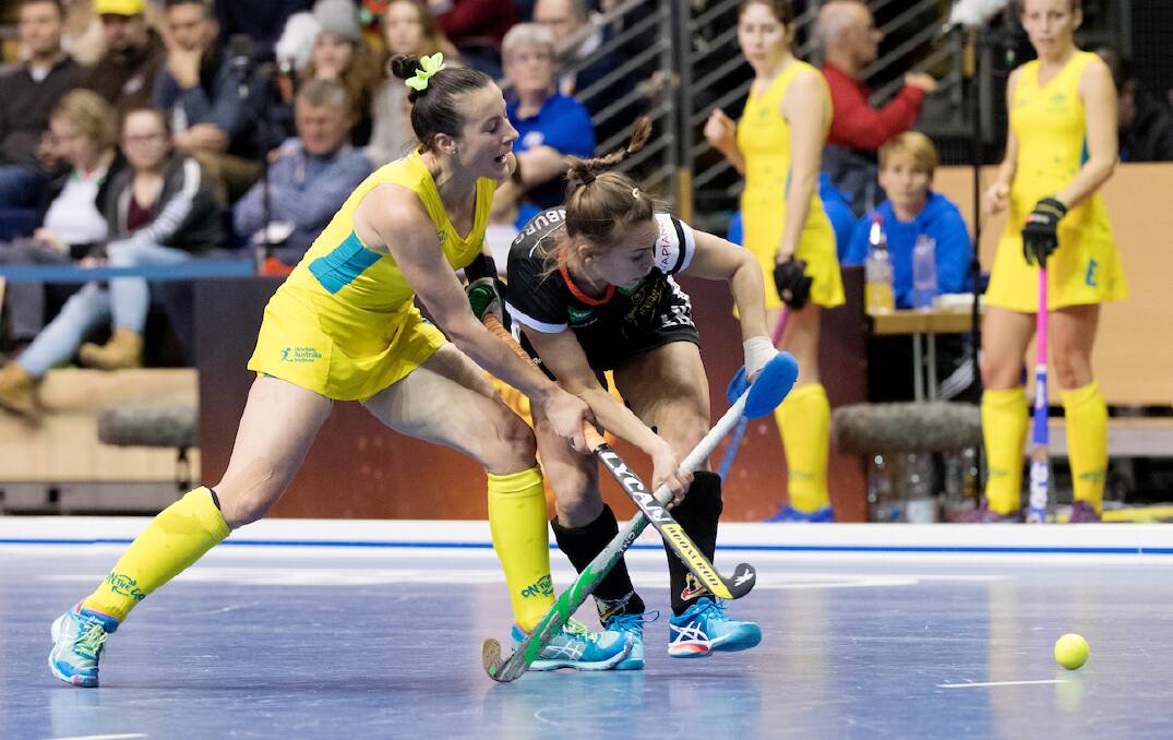BATTLING: Tamsin Bunt tussles with a German rival at the Women's Indoor Hockey World Cup. The Australians reached the quarter-finals. Photo: FIH/ World Sport Pics
