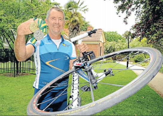 GOLD IN HAND: Bruce Goddard, with his gold and silver medals from the Cycling Australia Masters won in 2013. Photo: CHRIS SEABROOK 