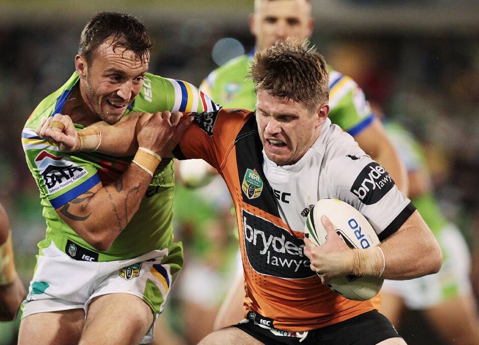Christopher Lawrence of the Tigers is tackled during the round eight NRL match between the Canberra Raiders and the Wests Tigers. (Photo by Stefan Postles/Getty Images)