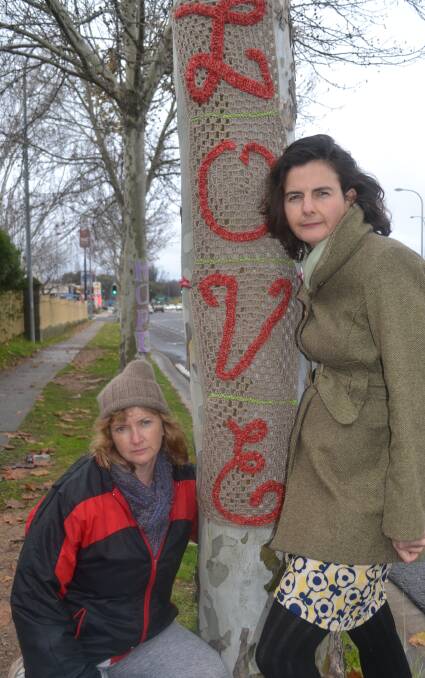 STITCH IN TIME: River Yarners members Judy Meadley and Sally Neaves helped wrap crocheted signs around London plane trees on Durham Street. 062016trees2
