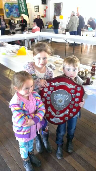 WINNING SMILES: Young Rory Stapleton won the black sheep section of the Burraga Show. He is seen here with sisters Gemma and Abby with his and many trophies won by his grandfather Mick Stapleton, also in the sheep section. 083016rural2