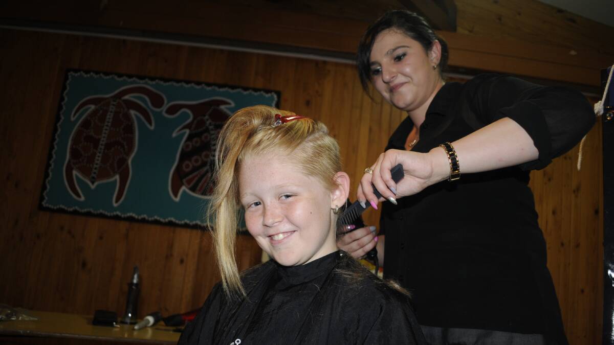 GOING, GOING, GONE: Jemayah Bailey, 11, has her head shaved by Katelyn Sarkis, from Allegro, at Kelso Public School. Photo: CHRIS SEABROOK 031517cut1a