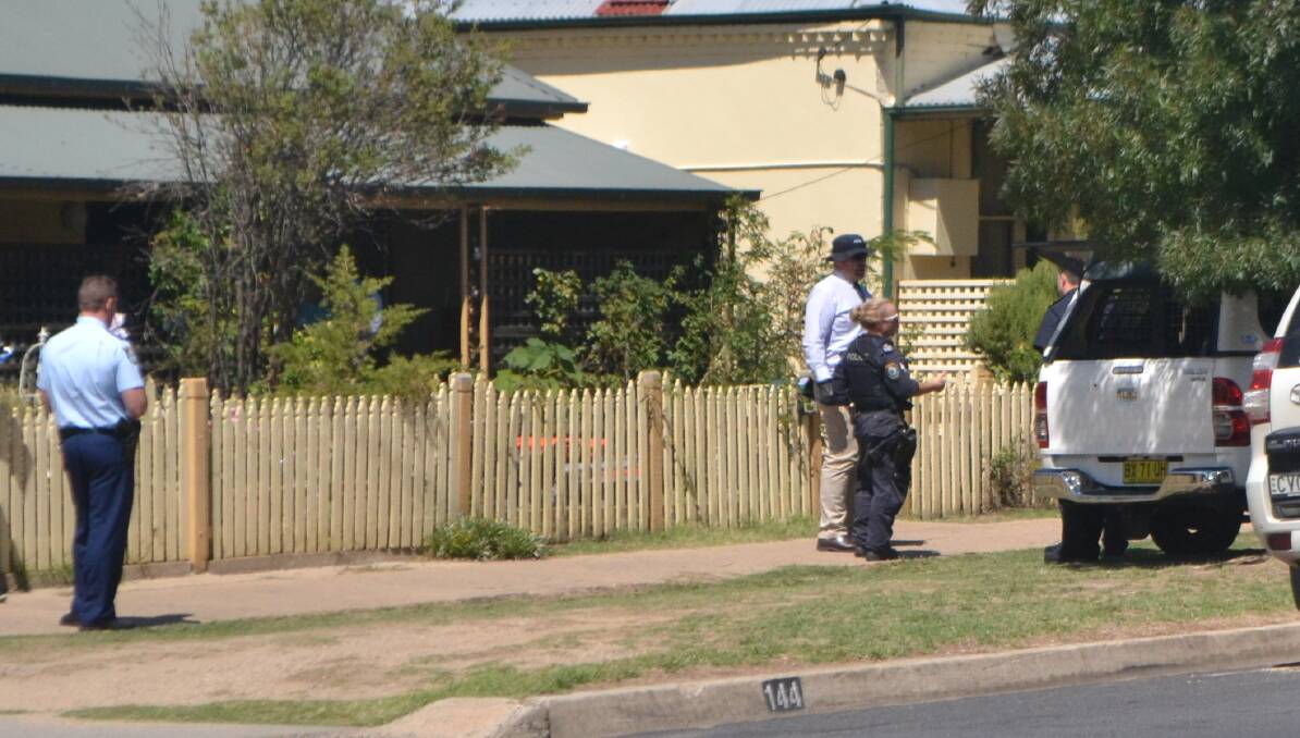 INVESTIGATION: Police officers executing a search warrant in Rankin Street on Thursday. Four men were refused bail after a brief court appearance on Friday.