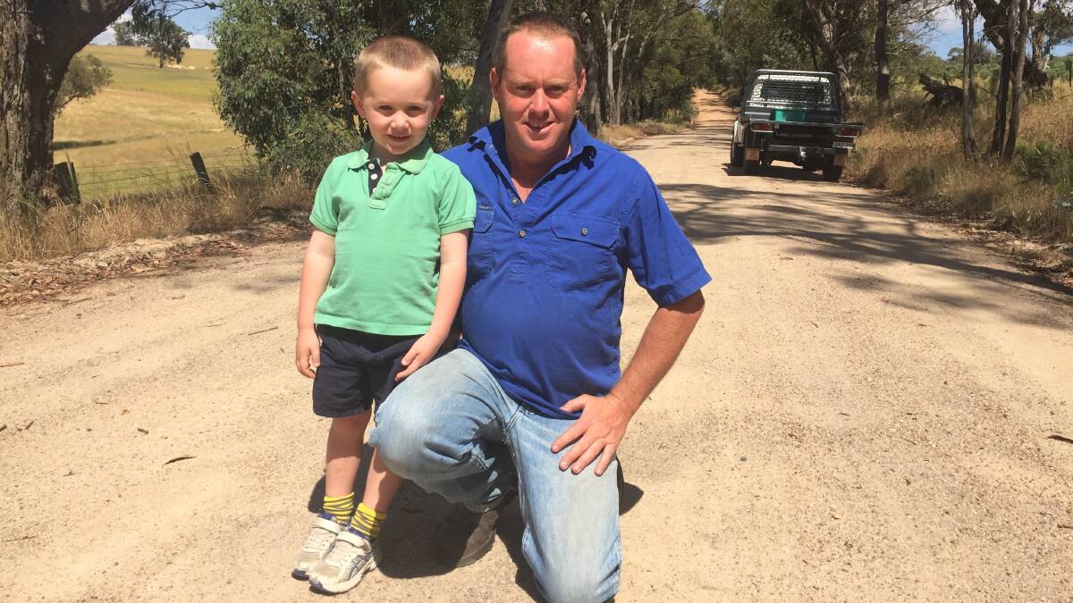 CONCERN: Farmer Jeremy Kensit and his son Harry, 5, on Whalans Lane, north of Bathurst, which Mr Kensit says is unsafe. Photo: MATT WATSON