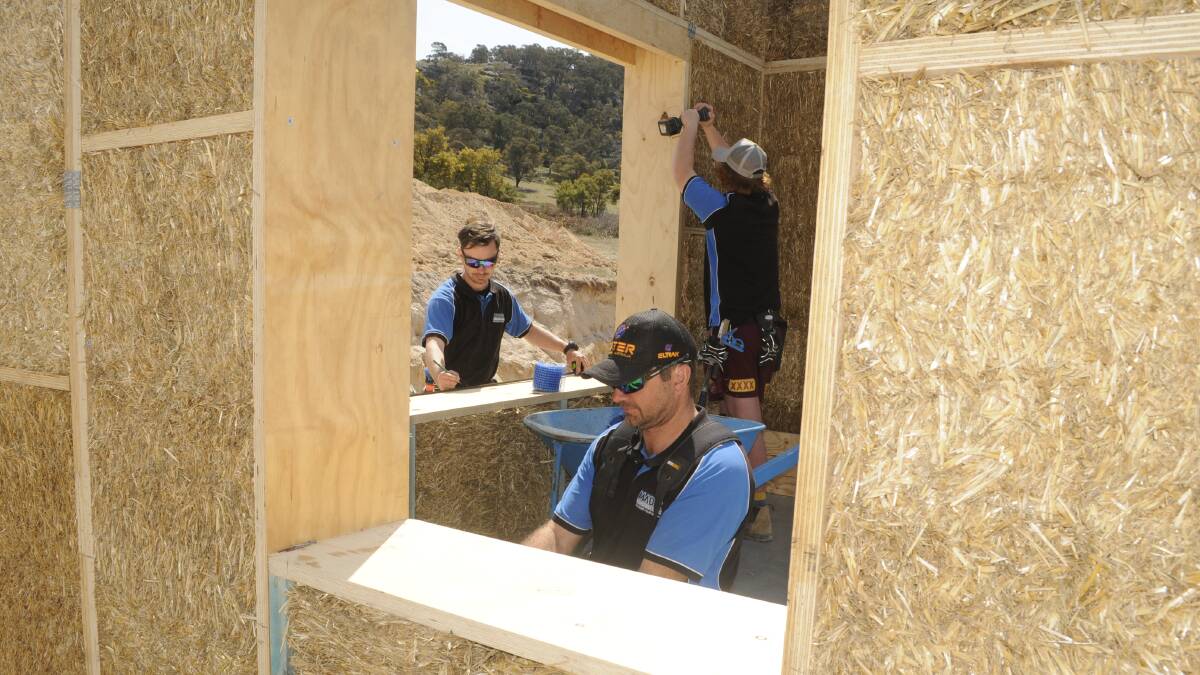 AT WORK: Rick Bosianek (front) and Hayden Crawford and Brent Macri from Madik Constructions working on the master bedroom of the straw house. Photo: CHRIS SEABROOK 092017cstraw1