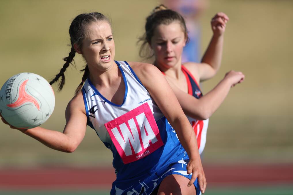 WIN NUMBER EIGHT: Collegians wing attack Tamara Thompson looks for options while Abigail Miller of All Saints' College closes in. Photo: PHIL BLATCH