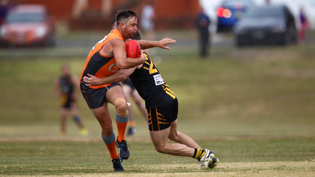 OOMPH: Bathurst Giants' Paul Jenkins takes a hit from an Orange Tigers opponent on Saturday. Giants went down by 30 at George Park. Photo: PHIL BLATCH