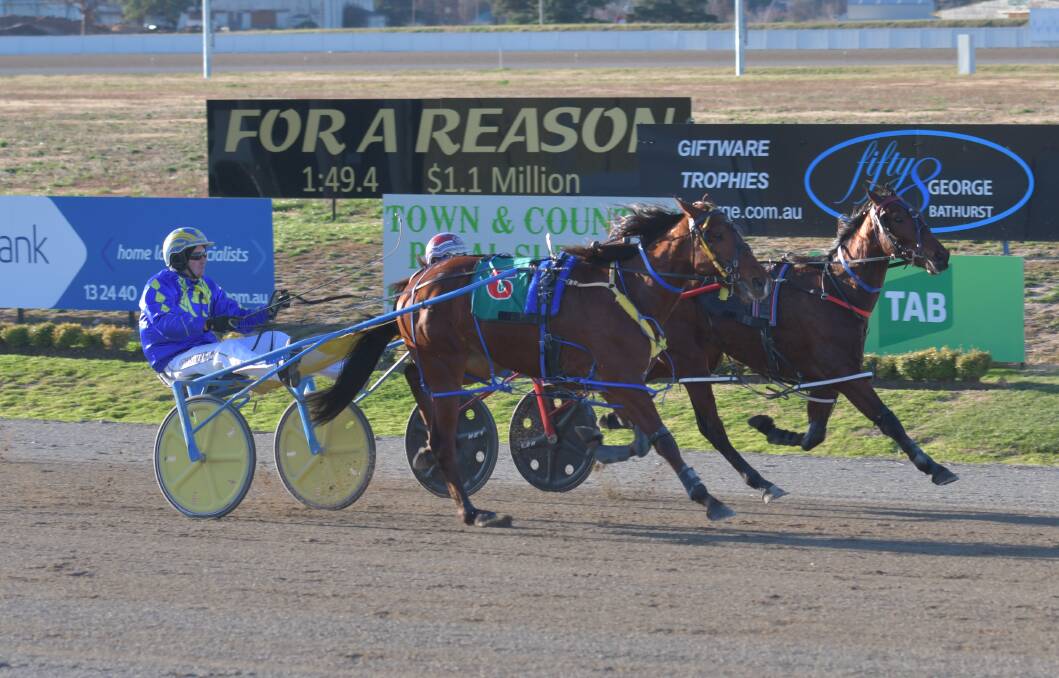 HERE I COME: Our Uncle Alan (closest to camera) goes by race favourite Rockin With Cheri in the final strides on Wednesday to claim his first career win at Bathurst Paceway. Photo: ALEXANDER GRANT
