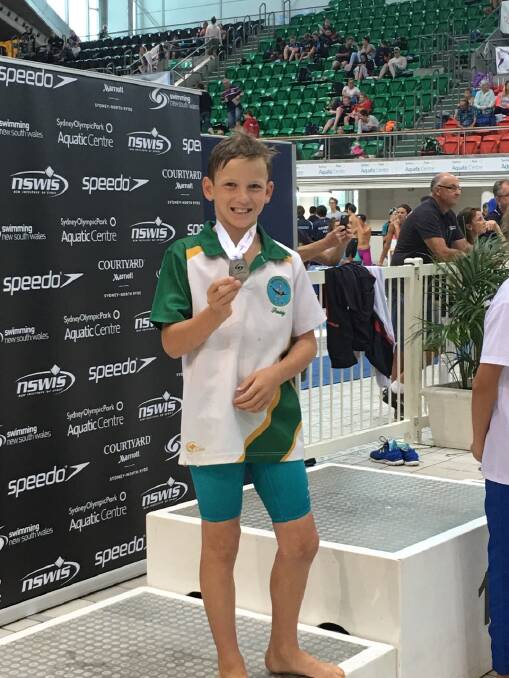 ON THE PODIUM: Patrick O'Hara celebrates after winning a silver medal in the men's 11 years 100m breaststroke at the NSW Country Championships at Homebush.