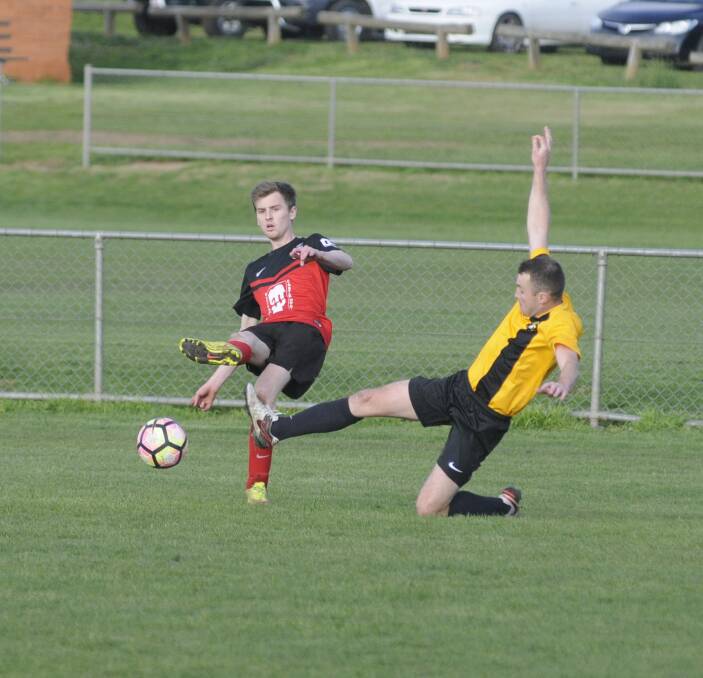 NO YOU DON'T: Panorama FC's James Cox clears the ball before a Lithgow Workmans defender can intercept during Sunday's Bathurst Distrct Football first grade preliminary final. Photo: CHRIS SEABROOK 091116csocr1