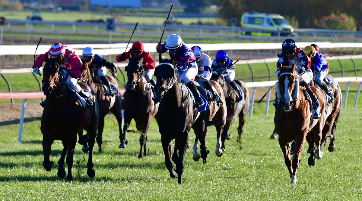 Fletchlo (centre, white cap) takes the lead from Brogans Creek (left), with De Forerunner (right) closing in late. Picture by Alexander Grant.