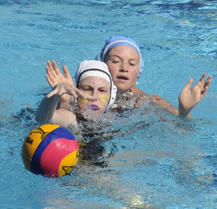 THAT'S MINE: UNSW Wests' Jessie Phelps reaches for the ball ahead of ACU Cronulla's Amber Carroll in the final of the U14s Girls Water Polo State Age Championships on Wednesday. Photo: CHRIS SEABROOK 122116cwpolo1