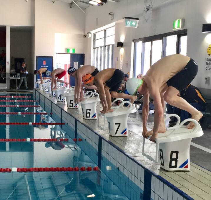 GET SET: Bathurst City Amatuer Swim Club co-coach Josh Stapley (closest to camera) was the open age champion at the Mountains and Plains Winter Short Course Meet.