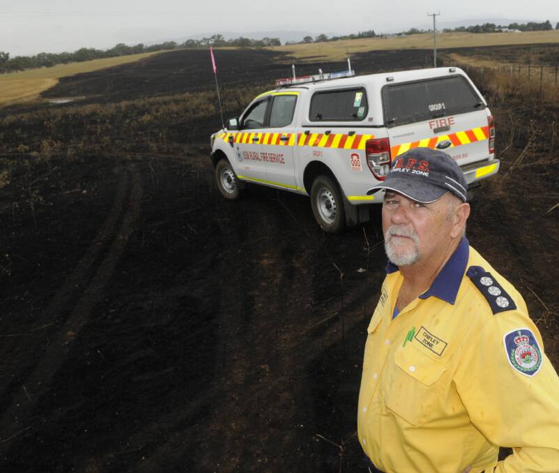 USE CAUTION: Chifley Zone group officer Maurice McMillen at the site of a fire that burnt through grass at Laffing Waters on Monday. It was just one of the recent blazes caused by machinery use. Photo: CHRIS SEABROOK 020717cgrassf1