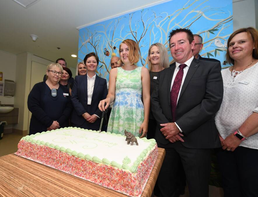 SPECIAL MOMENT: Aurora Bondareff (centre) had the task of cutting the cake to celebrate the opening of the newly renovated family and carer room. Photo: CHRIS SEABROOK 103018cmhealth1