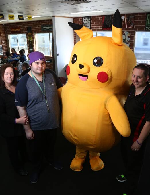 GREAT EFFORT: Game On Cards and Games owners Ann Bantoft and Tony Fisk (right), pictured with Ann's son Brad Williams and Pikachu. Photo: PHIL BLATCH 082716pbgame10