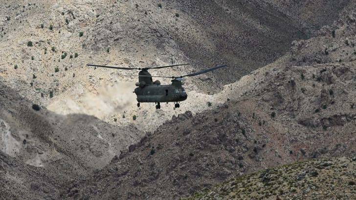 The mountainous terrain of Afghanistan dwarfs a CH-47D Chinook helicopter during a combat resupply mission in southern Afghanistan.