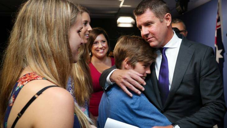 Mike Baird embraces his family after the emotional  press conference where he announced his resignation. Photo: Janie Barrett