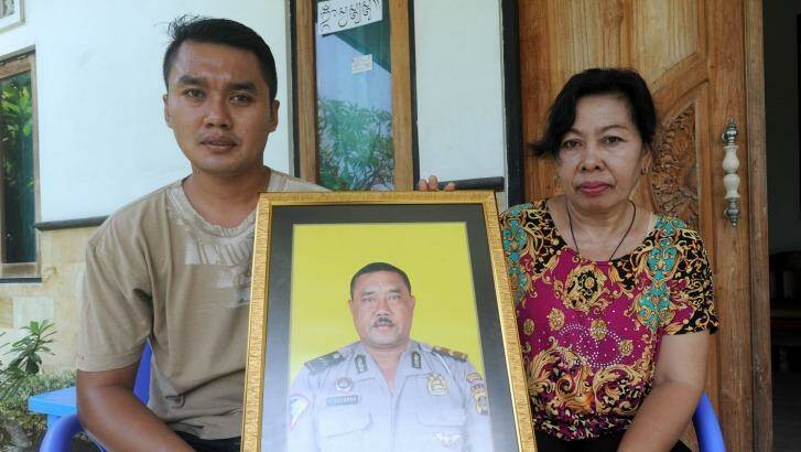 The widow of Wayan Sudarsa, Ketut Arsini, and her son Kadek Toni, hold a portrait of the police officer who was killed on Kuta beach.  Photo: Alan Putra